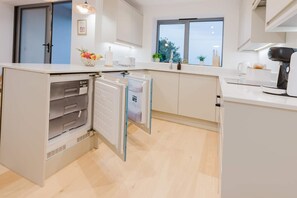 Eine moderne Küche mit Einbaukühlschrank, Kaffeemaschine und einem Fenster mit Blick.