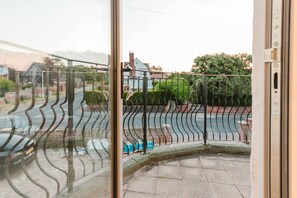 A view from a balcony with a metal railing, a clear sky, and a residential street with houses and greenery in the background. - Broadstairs Sea-view 2-balcony Flat FT4 by Adliv (Broadstairs)