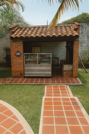 A small outdoor kiosk with a tiled roof and brick walls, featuring a glass display case and a bench. - Ideal for a family getaway; pet-friendly 🌿 A rural retreat near Cali🏊 (Cali)