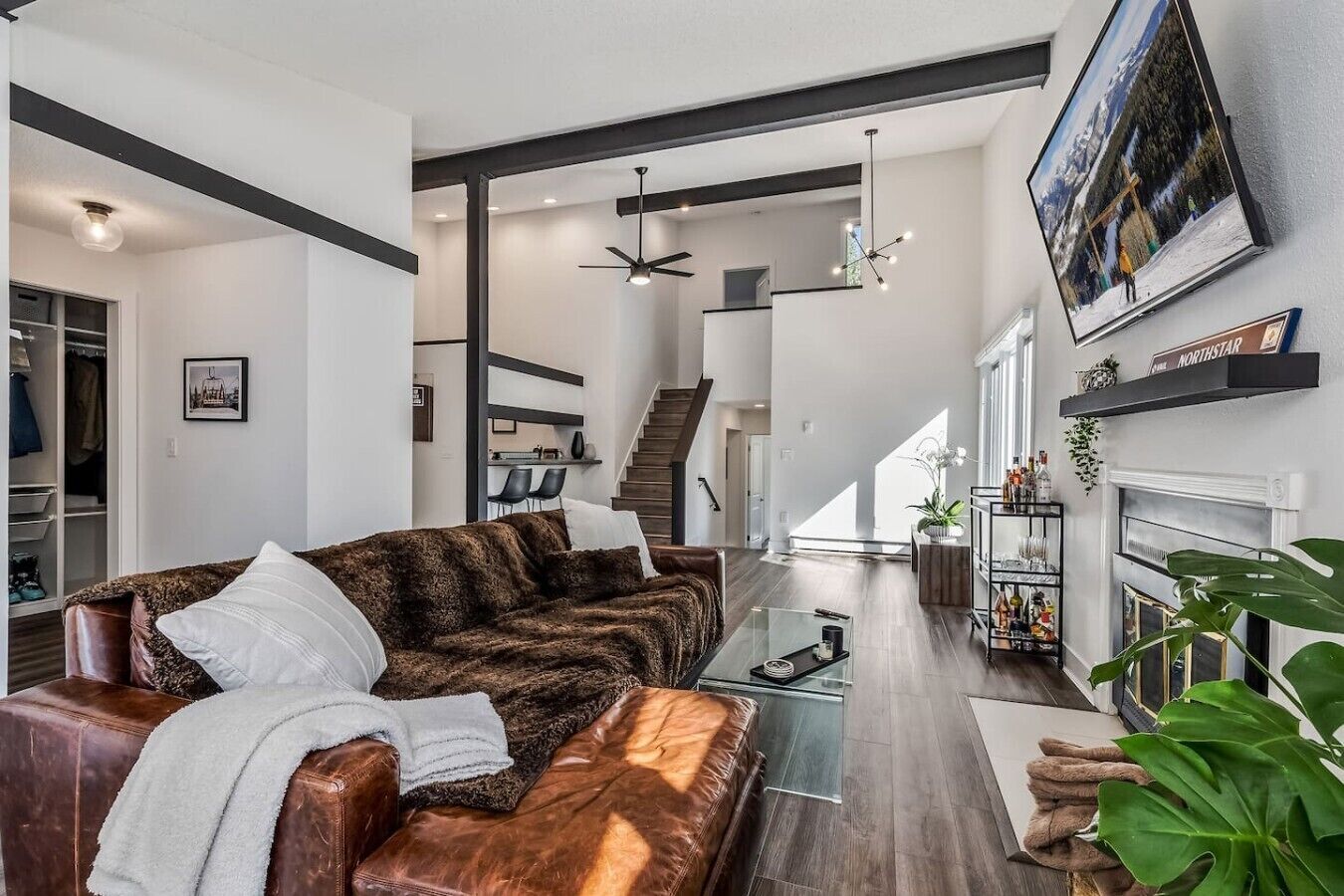 A modern living room with a leather sofa, a glass coffee table, and a fireplace.
