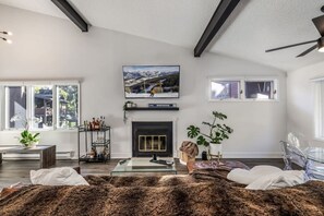 A modern living room with a fireplace, a mounted TV, and a glass coffee table. - EagleVail Retreat | Near Vail & Beaver Creek (Avon)