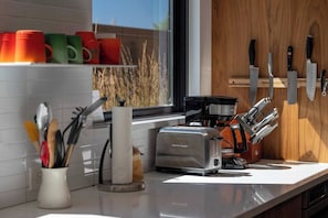 A kitchen with a toaster, a coffee maker, and a knife block on the counter. - Ridgeline Retreat | Modern 4BR, Big Mountain Views (Tabernash)