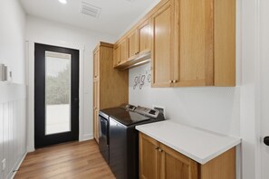 A kitchen with wooden cabinets, a stainless steel stove, and a dishwasher. - Quiet Pond Retreat - Minutes from A&M - Sleeps 12 (College Station)