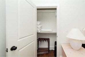 A closet with hanging space and a lamp on a bedside table. - House with Pool - Bay St. Louis Downtown (Bay St. Louis)