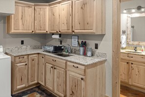 A kitchen with wooden cabinets, granite countertops, and a built-in dishwasher.