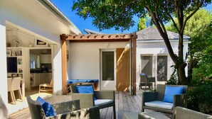 Eine Terrasse im Freien mit Korbmöbeln und einer Pergola.