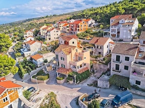A residential area with terraced houses, narrow streets, and a hilly backdrop. - One Bedroom Apartment with Terrace an Sea View (Postira)