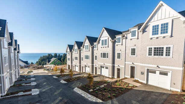 A residential area with multi-story houses, a driveway, and a view of the ocean. - Seascape Lookout Townhome, Large Kitchen & Pet Friendly (Depoe Bay)