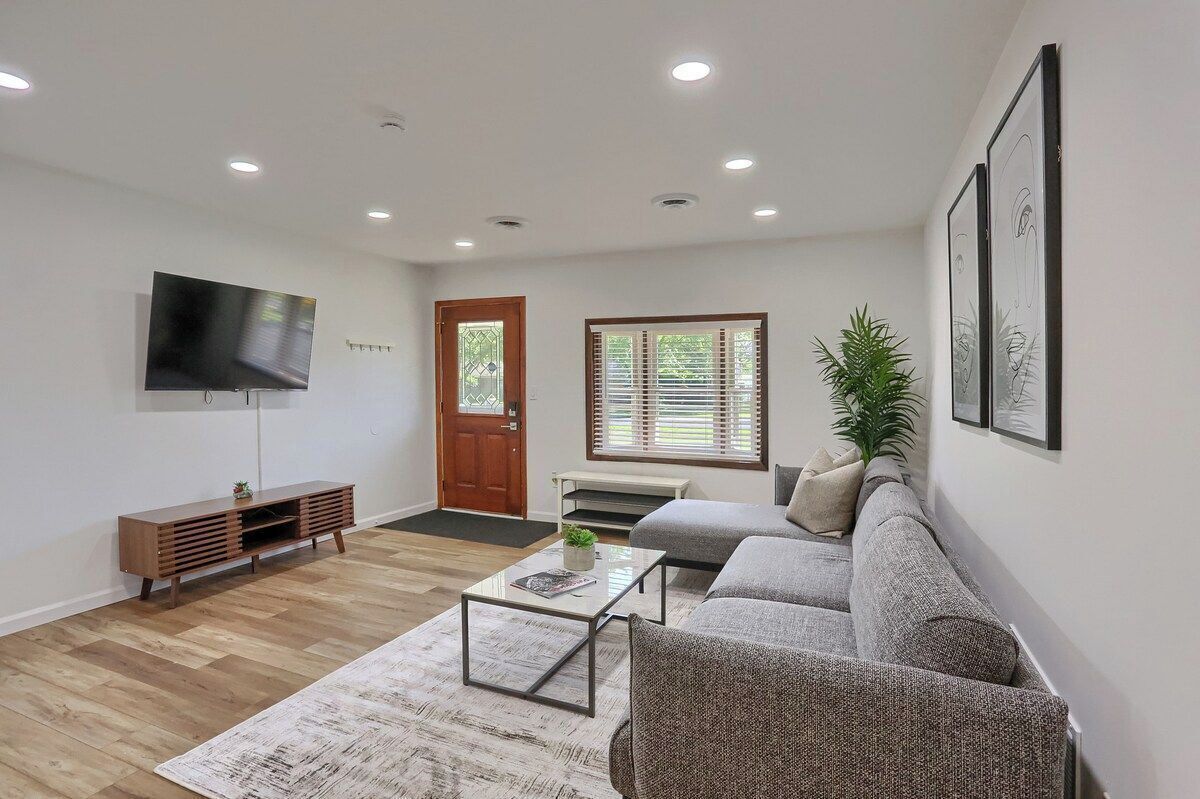 A modern living room with a sofa, coffee table, and a flat-screen TV.
