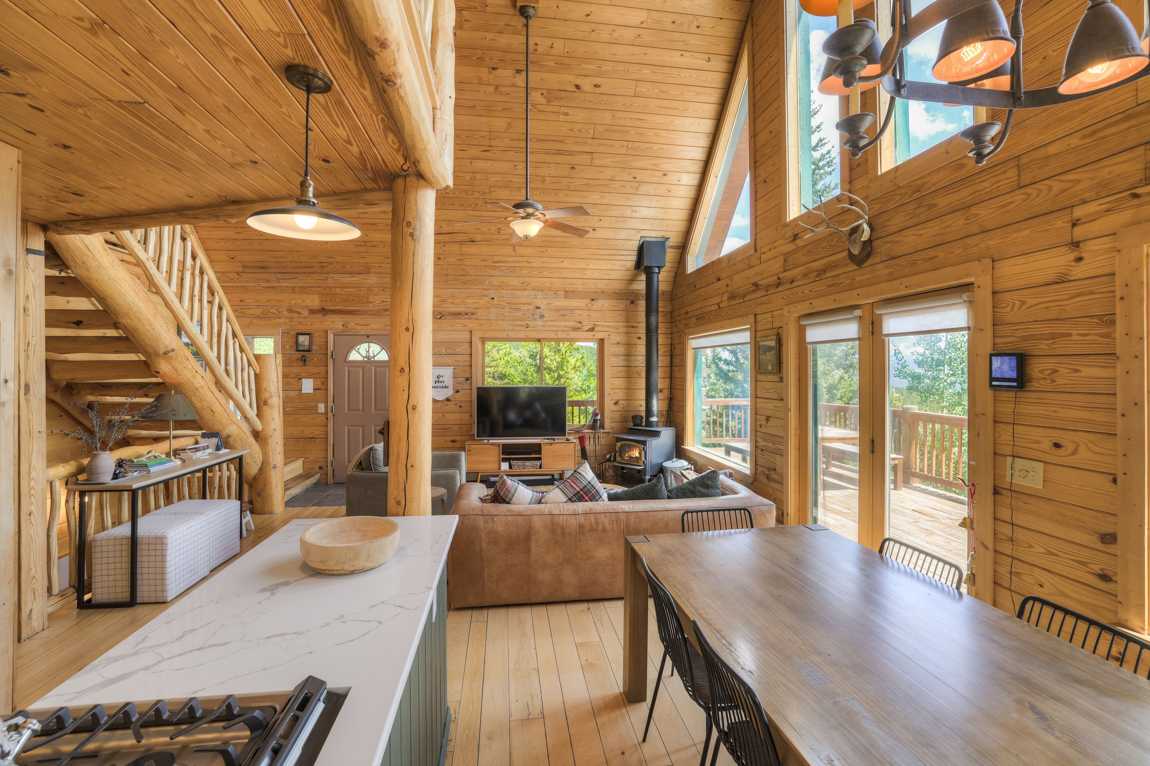 Ein Holzblockhaus-Innenraum mit Essbereich, Küche und Kamin.