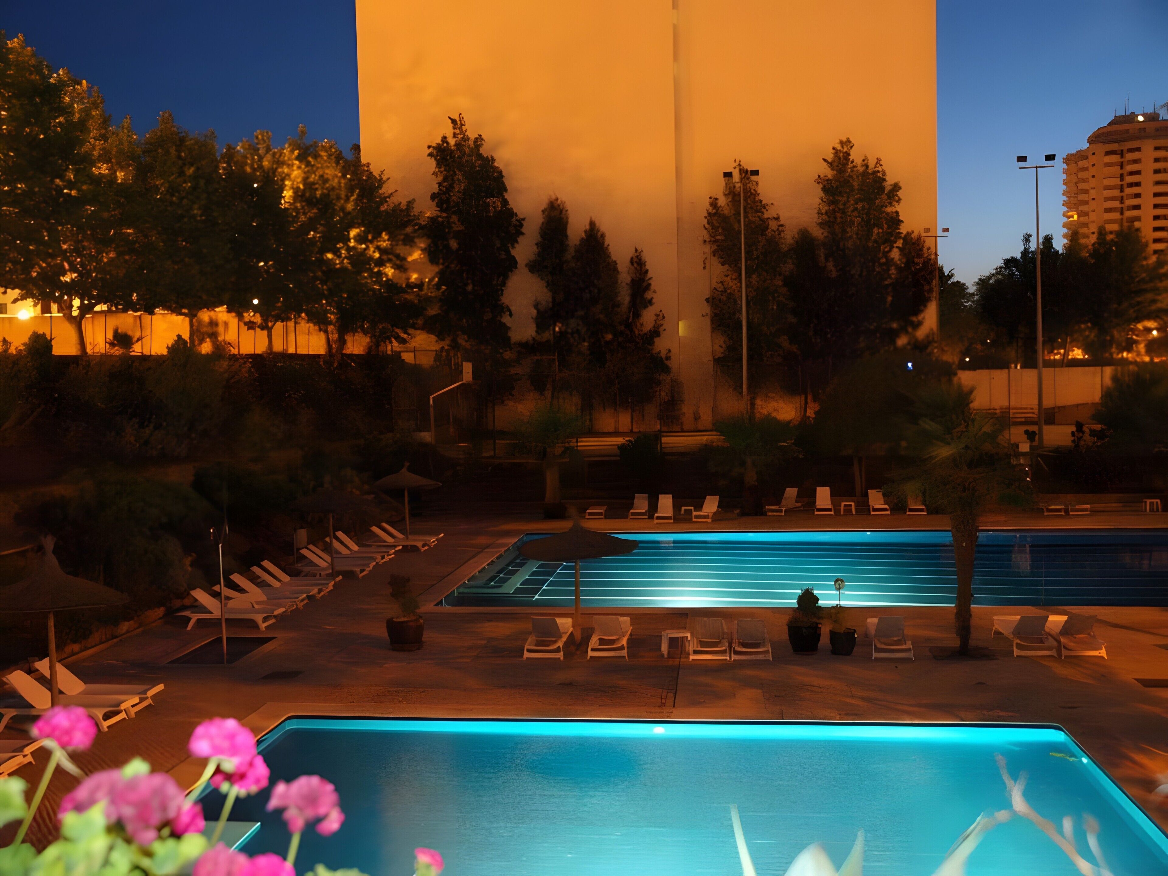 Zona de piscina con sillones de descanso y una piscina cristalina.