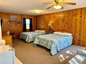 A room with two beds, a ceiling fan, a heater, and a window with curtains. - Driftwood Resort  (Bull Shoals)
