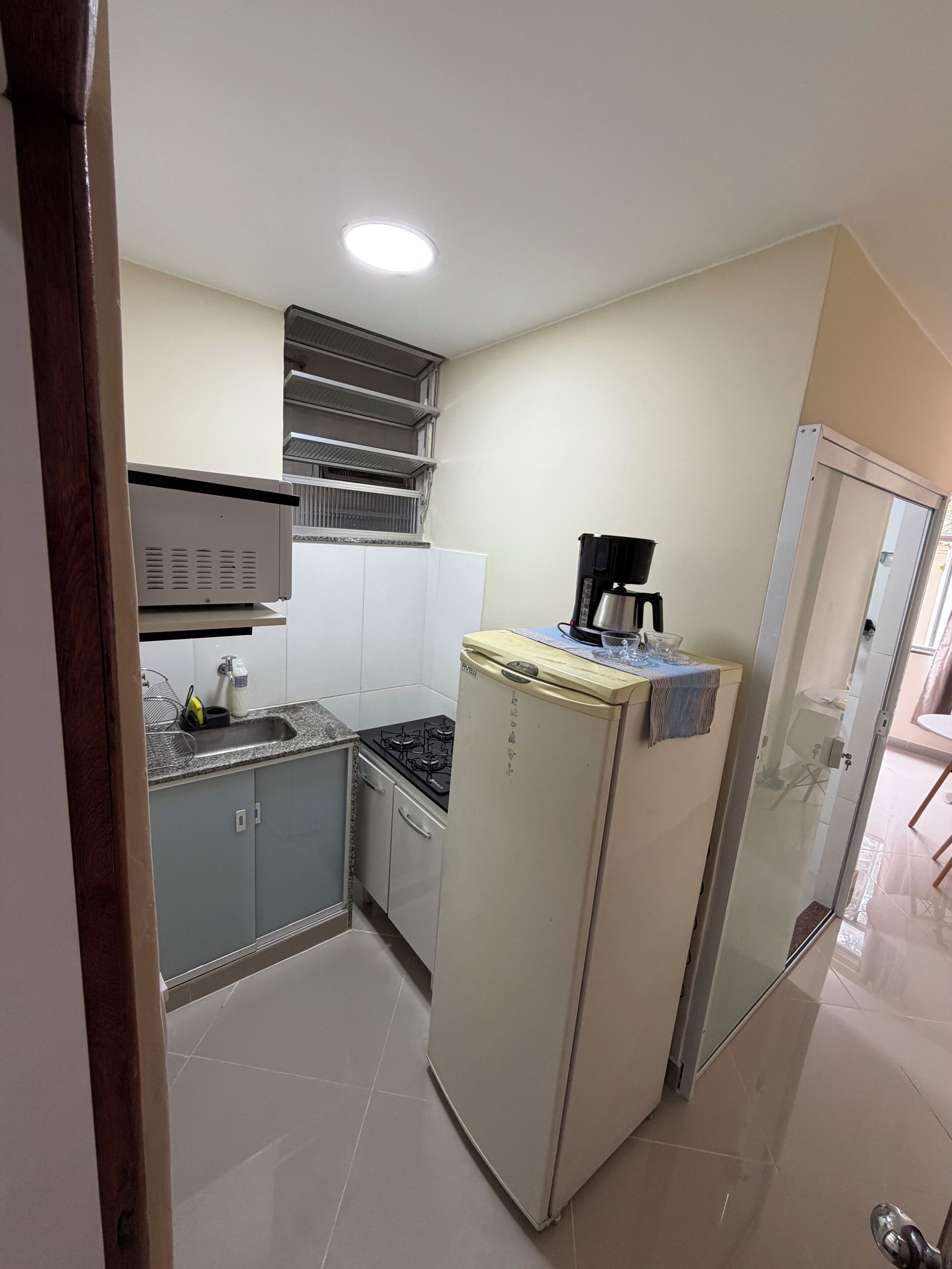 Una cocina compacta con refrigerador, estufa y pileta.