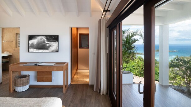 A modern interior with a wooden desk, a framed photograph, and a view of the ocean through large windows. - Villa Ocean Vibes (2 bedrooms) (San Bartolomé)