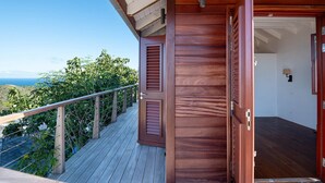 A wooden deck with a view of the ocean, a wooden door, and a small room with a window. - Villa Ocean Vibes (2 bedrooms) (San Bartolomé)