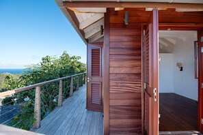 A wooden deck with a view of the ocean, a wooden door, and a small room with a window. - Villa Ocean Vibes (2 bedrooms) (San Bartolomé)