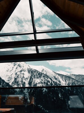 A room with a large window overlooking a snow-covered mountain. - Kunç Konakları (Çamlıhemşin)