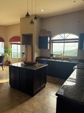A spacious kitchen with a large island, a refrigerator, and a window offering a view of the outdoors. - Fantastic 3-bedroom house in Playa Hermosa. Best views in of Playa Hermosa (Playa Hermosa)