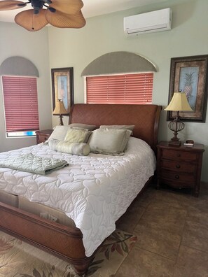A bedroom with a bed, nightstands, a ceiling fan, and a wall-mounted air conditioner. - Fantastic 3-bedroom house in Playa Hermosa. Best views in of Playa Hermosa (Playa Hermosa)