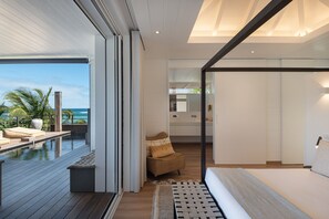 Ein modernes Interieur mit Pool, einer Couch und Blick auf den Ozean.