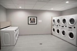 Een wasserette met meerdere wasmachines en een droger.