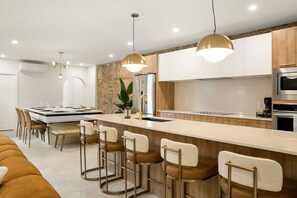 A modern kitchen with a central island, bar stools, and pendant lighting. - Massive 9BR Luxury Stay • Plateau • sleep 22 (Montréal)