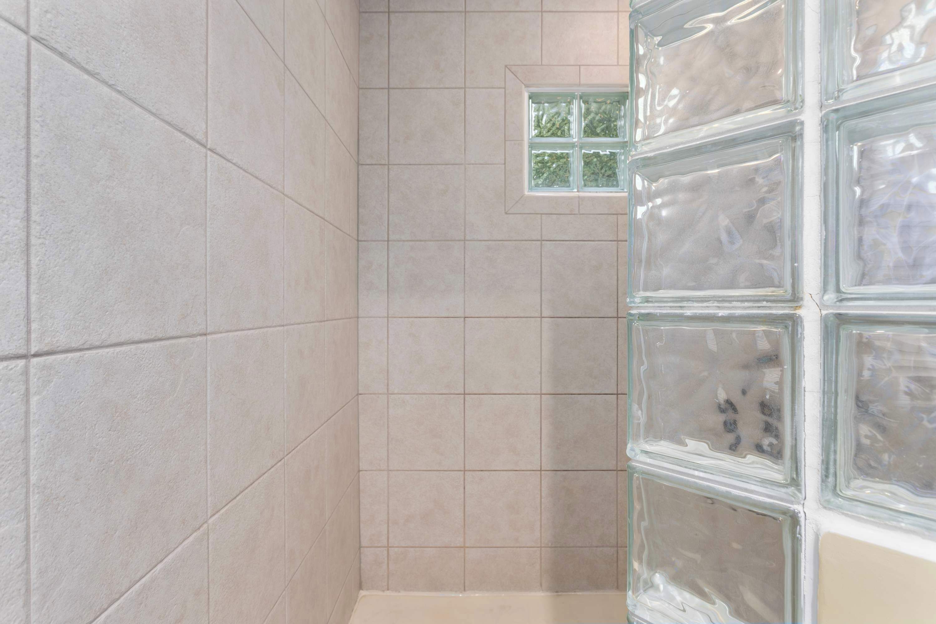 Un box de ducha con azulejos y un mamparo de vidrio esmerilado.