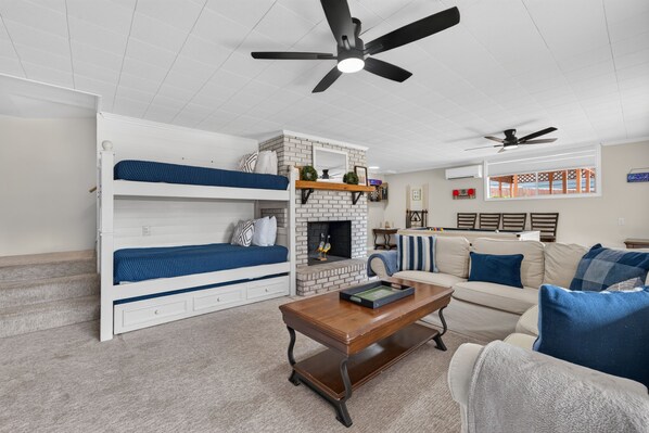 A living room with a fireplace, a sofa, a coffee table, and a bunk bed.