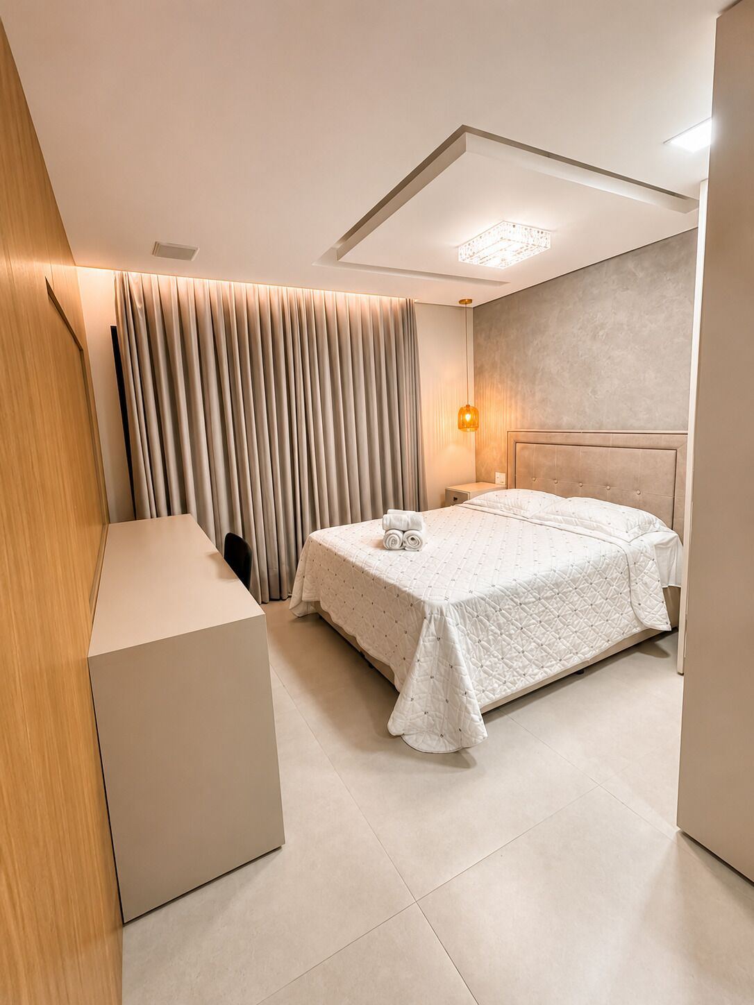 Une chambre d’hôtel moderne, équipée d’un lit, d’une table de chevet et d’un bureau.