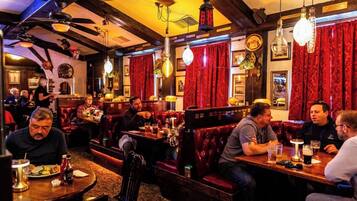 A restaurant interior with booths, tables, and hanging light fixtures.
