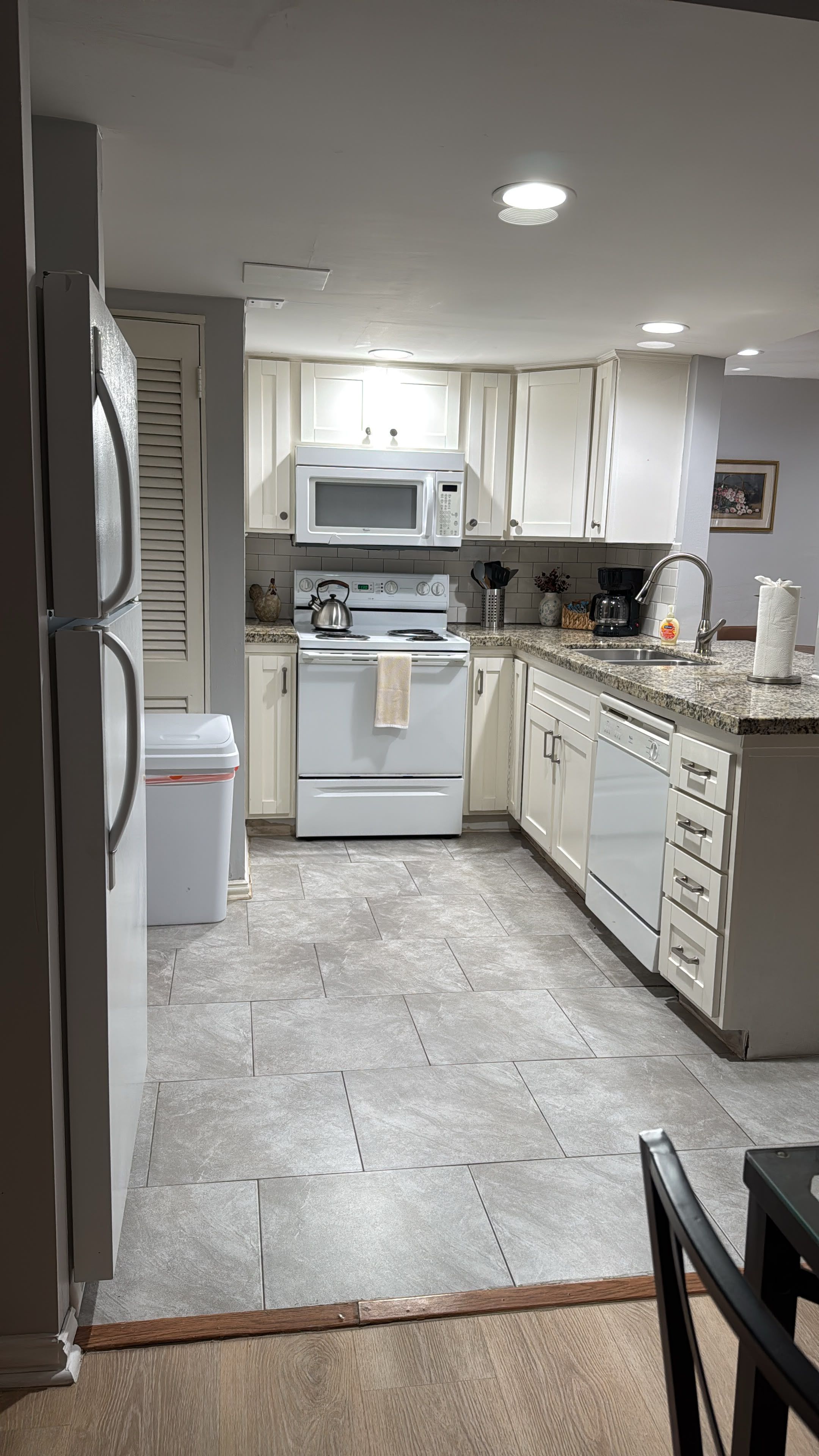 A kitchen with white cabinets, a microwave, stove, and a dishwasher.