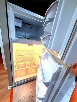 An open refrigerator with a freezer compartment visible. - Montrose nest - Large 1 King Br + 2nd small BR (Houston)