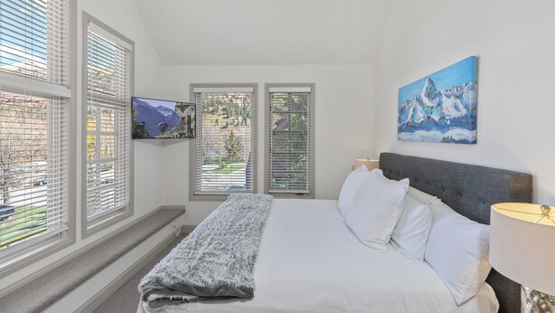 A bedroom with a bed, a TV mounted on the wall, and a painting. - Ski In/Out Sunset Luxury: Etta Place Too 115 at the base of Lift 7 (Telluride)