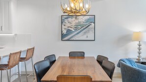 A dining area with a wooden table, black chairs, a chandelier, and a framed picture on the wall. - Ski In/Out Sunset Luxury: Etta Place Too 115 at the base of Lift 7 (Telluride)