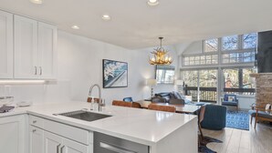 A modern kitchen with a central island, a dining area with a view, and a cozy seating space. - Ski In/Out Sunset Luxury: Etta Place Too 115 at the base of Lift 7 (Telluride)