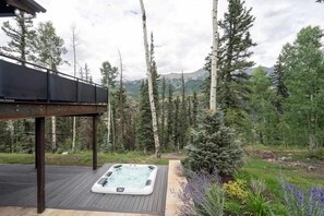 Ein Whirlpool auf einer Holzterrasse mit Blick auf das Gebirge.