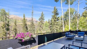 An outdoor deck with seating and a flower planter. - Luxe Telluride Oasis - Hot Tub & Deck & Views (Mountain Village)