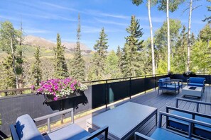 Eine Terrasse im Freien mit Sitzgelegenheit und einem Blumenbeet.