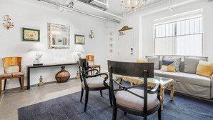 A modern living room with a sofa, chairs, a coffee table, and artwork on the walls. - Cozy 1-bedroom Grnd Flr apt. Sleeps 4, Pool & Free Parking (Los Angeles)