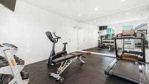 A gym with exercise equipment including a treadmill, stationary bike, and weights. - Cozy 1-bedroom Grnd Flr apt. Sleeps 4, Pool & Free Parking (Los Angeles)