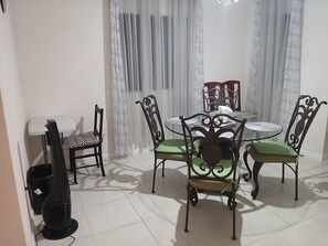 Ein Essbereich mit einem runden Tisch, Stühlen und einem Fernseher.