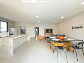 A modern kitchen with a granite countertop, a built-in microwave, and a refrigerator.