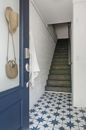 A staircase with a blue and white star-patterned floor leading to a room. - Sully & Sonshine | 3 BR Near Sullivan's Island (Mount Pleasant)