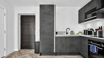 A modern kitchen with a built-in fridge, a microwave, and a stove.