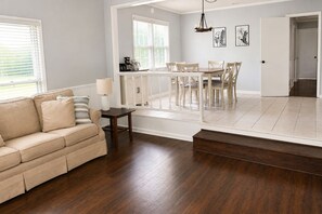 Ein Wohnzimmer mit einer Couch, einem Couchtisch und einem Essbereich mit Stühlen und einem Tisch.