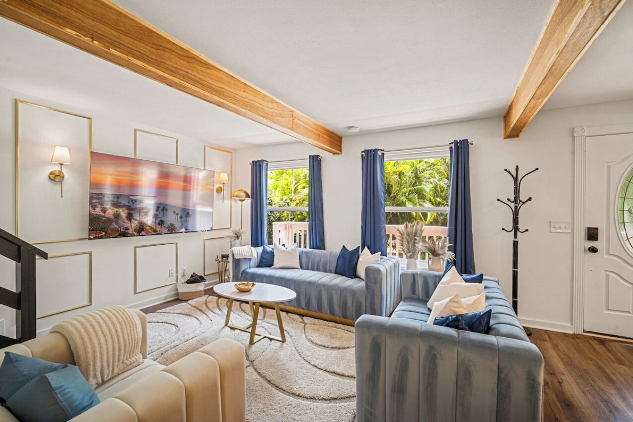 A living room with a sofa set, a coffee table, and a painting on the wall.