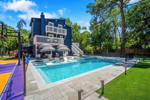 A swimming pool with a deck, lounge chairs, and a multi-level building with a balcony. - Entire home in Seminole, Florida, United States (Seminole)