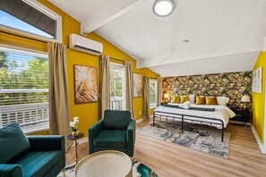 A bedroom with a bed, two chairs, a small table, and a window with curtains. - Entire home in Seminole, Florida, United States (Seminole)