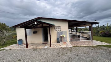 A small building with a covered entrance, a window, and a door.