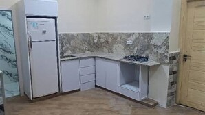 A compact kitchen with a built-in refrigerator, a gas stove, and a sink.